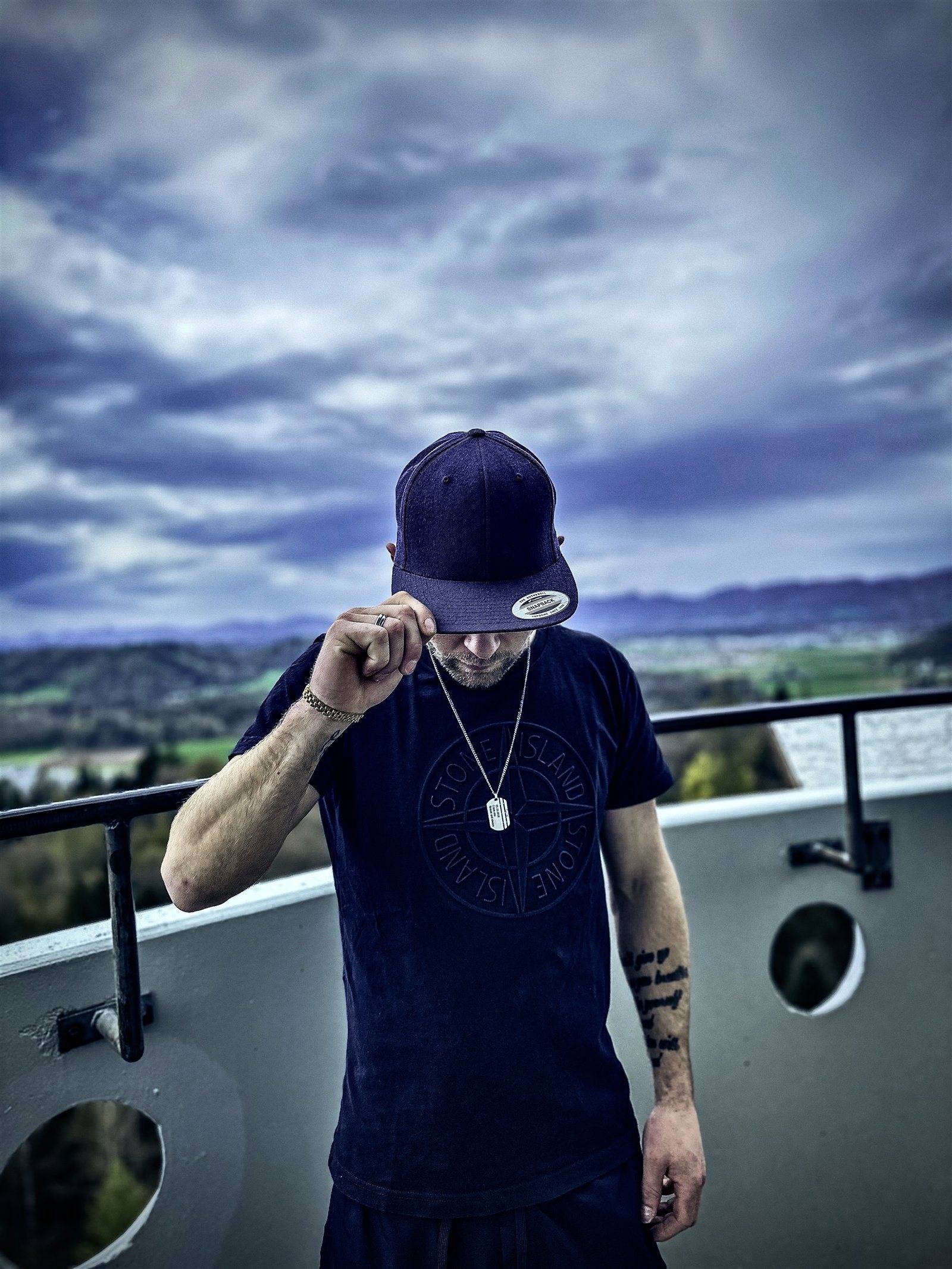 LAIN auf einem Balkon unter Wolken