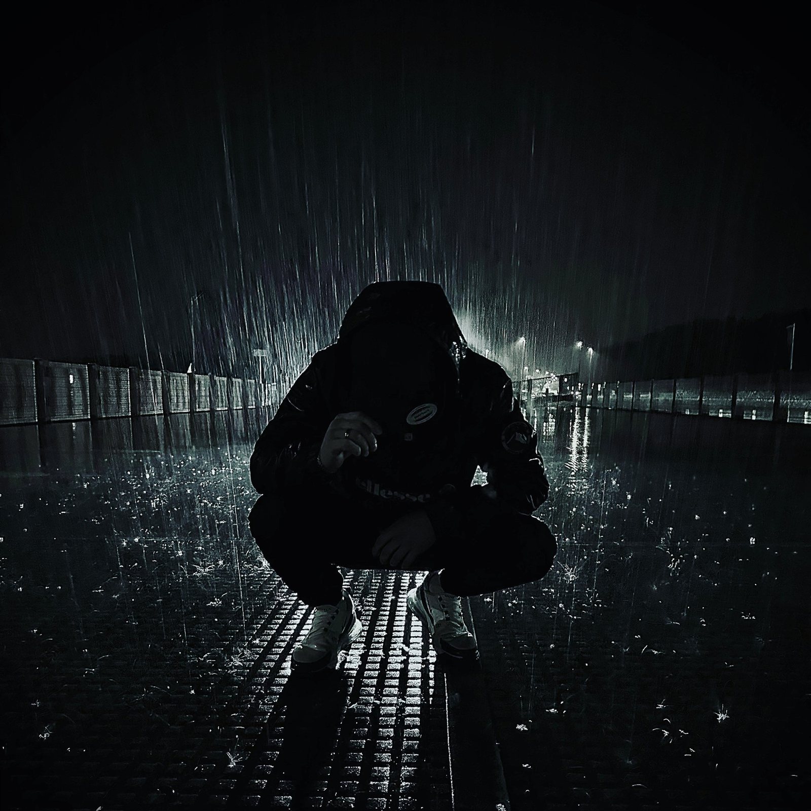 LAIN kauert im Regen in der Nacht